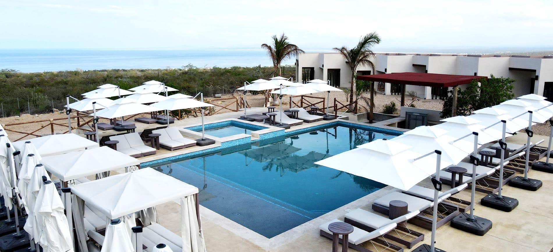 Pool, white cabanas and sun loungers at Mística Boutique Hotel in El Sargento
