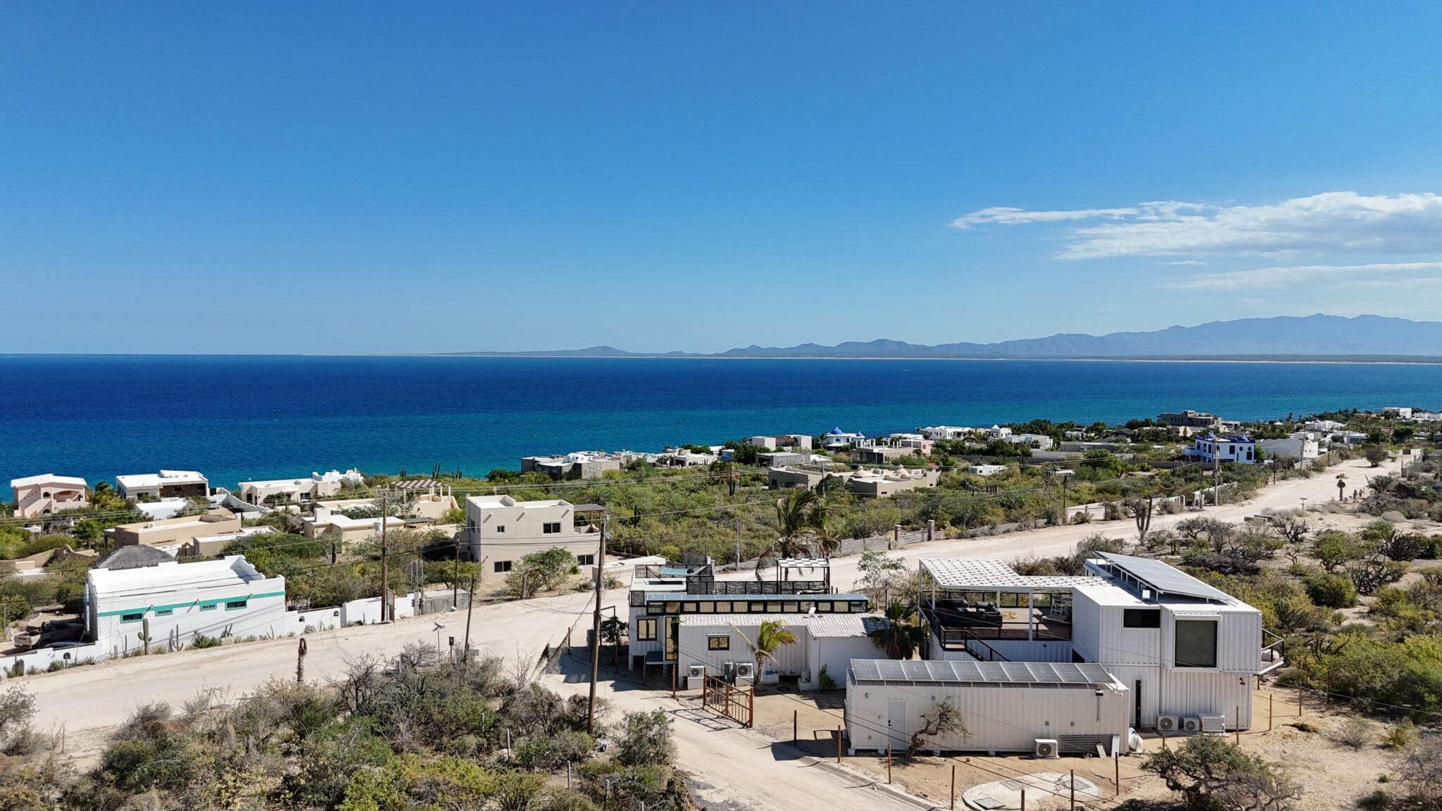 Drone view of 20 Knots and 30 Knots, rooftop solar panels and the bay in El Sargento